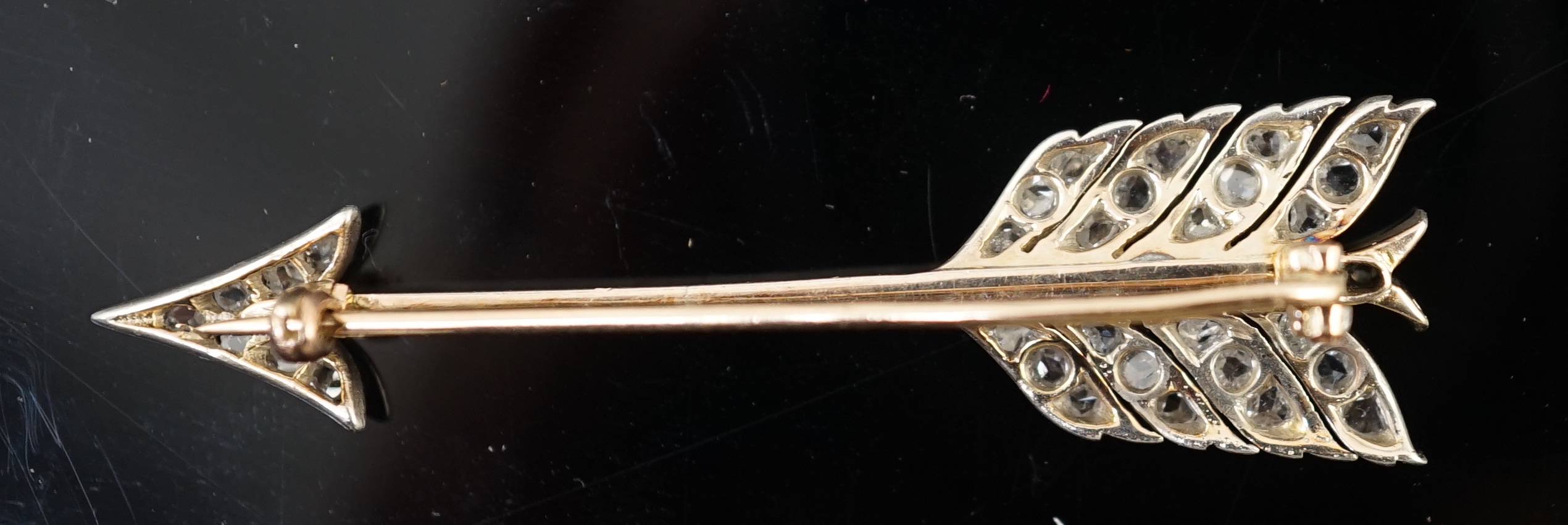 An early 20th century gold, platinum and rose cut diamond cluster set arrow brooch